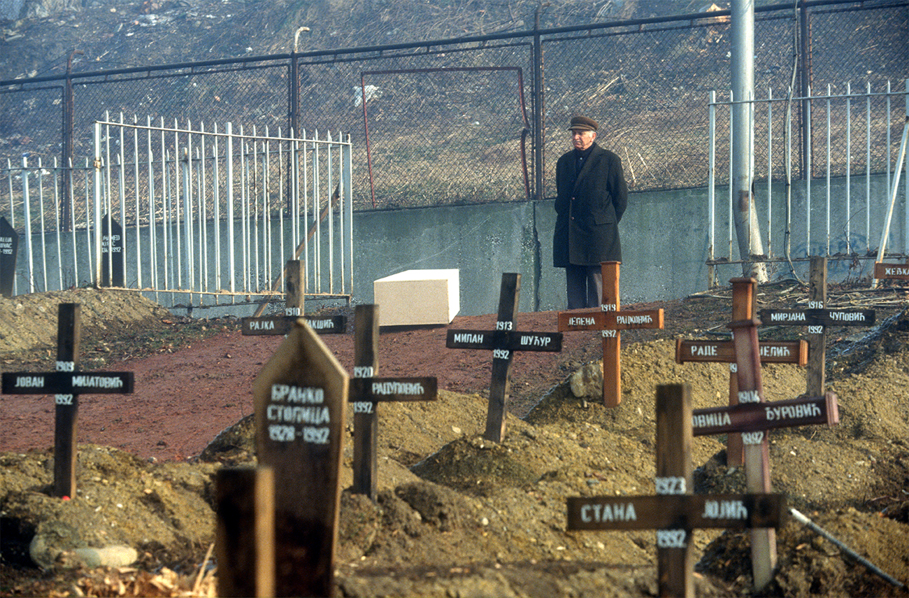 1993. Homme avec cercueil de sa femme attend le fossoyeur. Cimetière du Lion à Sarajevo.